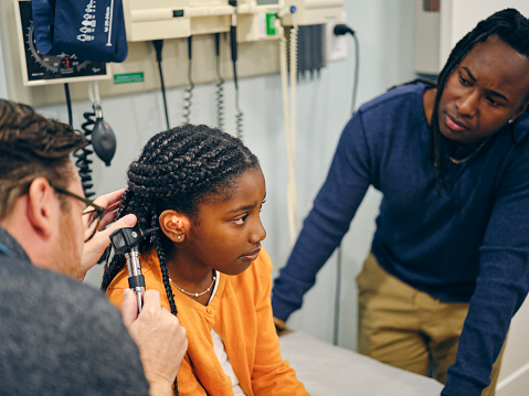 A father brings his daughter do the doctor’s office to see the pediatrician for an ear exam.