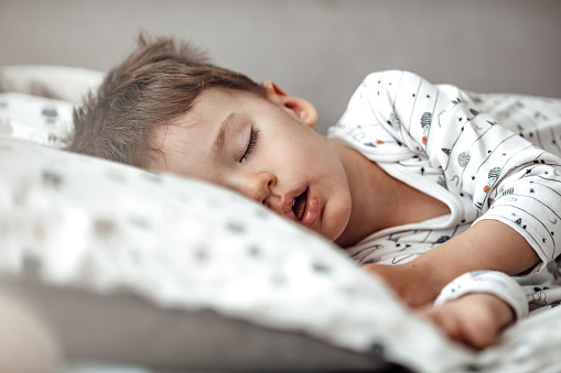 Young boy sleeping in his bed.