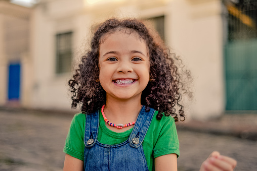 Small girl smiling on the street. looking at the camera