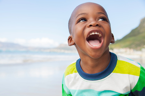 Young boy smiling with a wide open mouth.