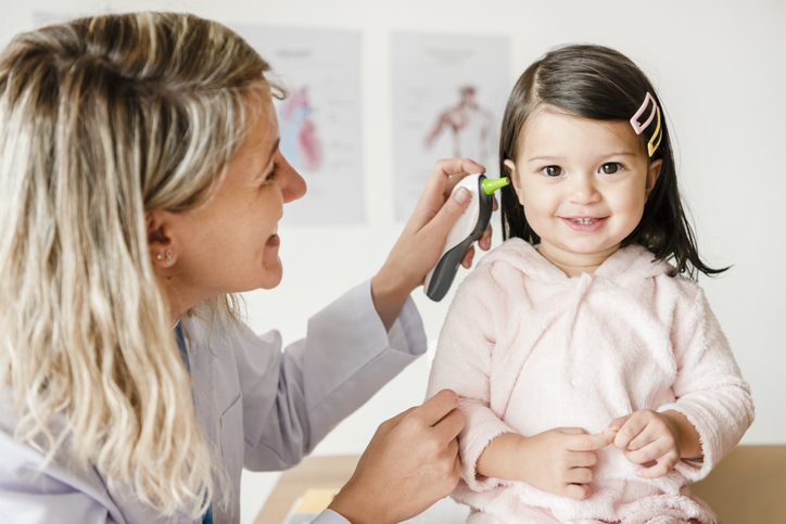 ENT specialist examining a young girl's ear.